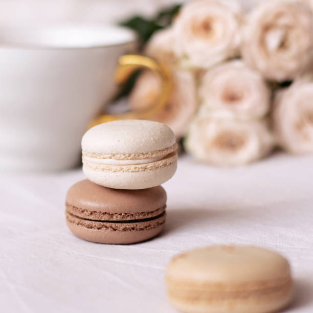 istock Vanilla and chocolate macaroons on white roses background 1307992345