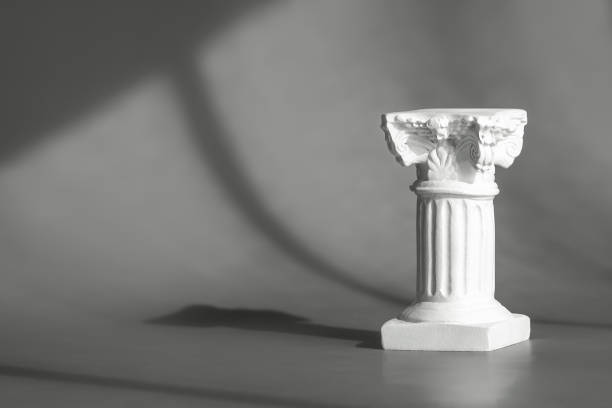 istock Roman marble column backdrop with art deco decor, display, mockup. Gray background for product presentation with shadows and light from windows. Window natural shadow overlay effect 1307992450