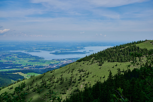 focused on the green hill, in the distance is blurred the Chiemsee, viewn from Kampenwand, a famous mountain in Bavaria, Germany