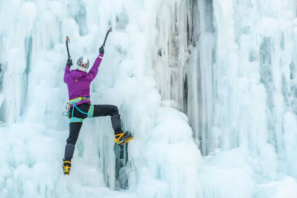 Ice climb with ice-axe Woman with ice climbing axe hiking at a frozen waterfall Icefall stock pictures, royalty-free photos & images