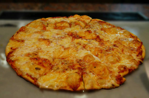 istock Cheesy whole pizza with very thin crust in soft background 1307997149