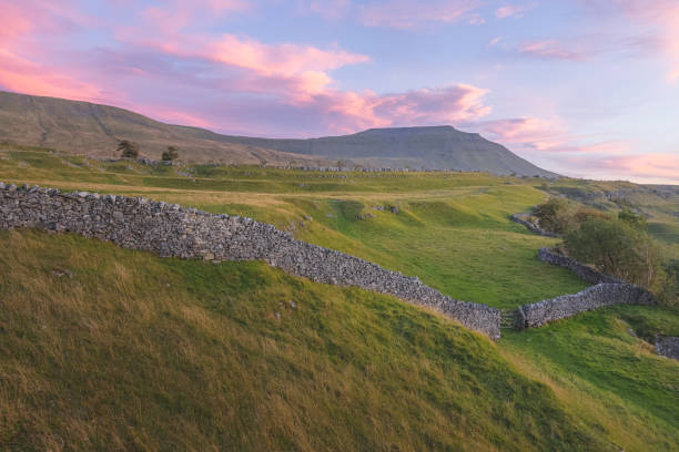 Southerscales, Yorkshire Dales Vibrant, colourful sunrise or sunset sky over the beautiful countryside landscape of limestone pavement old stone walls at Southerscales in the Yorkshire Dales National Park, UK. ingleborough stock pictures, royalty-free photos & images