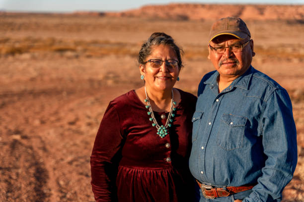 ein glücklicher, lächelnder indianer-ehemann und -frau in der nähe ihres hauses in monument valley, utah - navajo american culture indigenous culture women stock-fotos und bilder