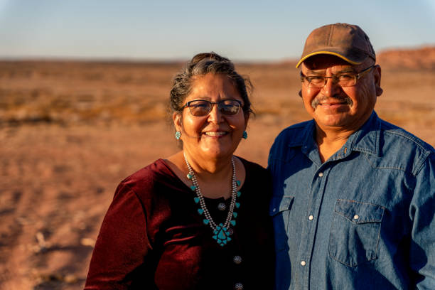 un feliz y sonriente esposo y esposa nativo americano cerca de su casa en monument valley, utah - navajo fotografías e imágenes de stock