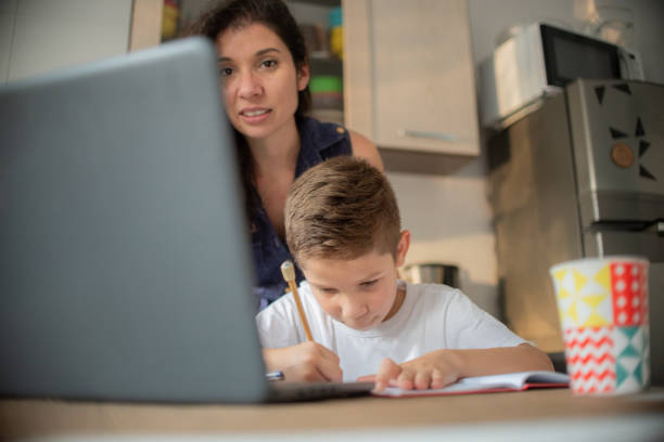 istock Mother helping son during online class at home. 1308005994