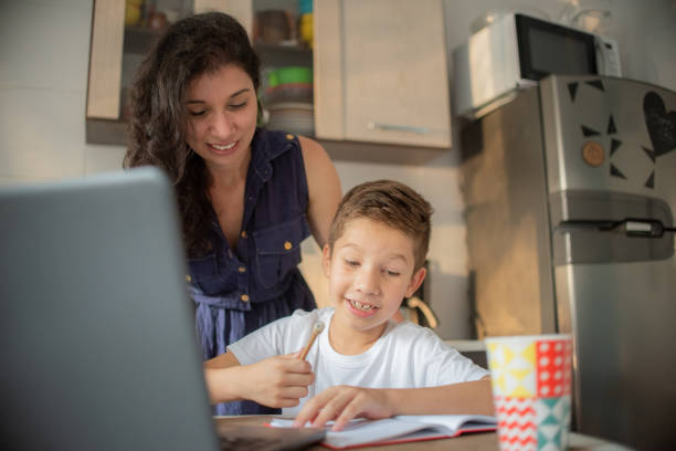 istock Mother helping son during online class at home. 1308005998
