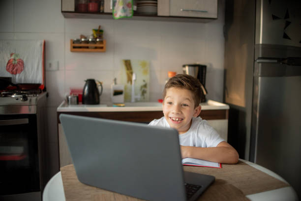 istock Little boy attending to online class from home. 1308006030