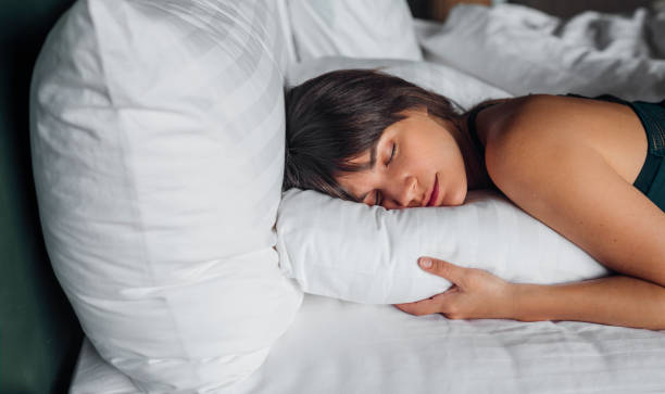 istock Beautiful Young Woman Sleeping in a King-sized Bed 1308007180