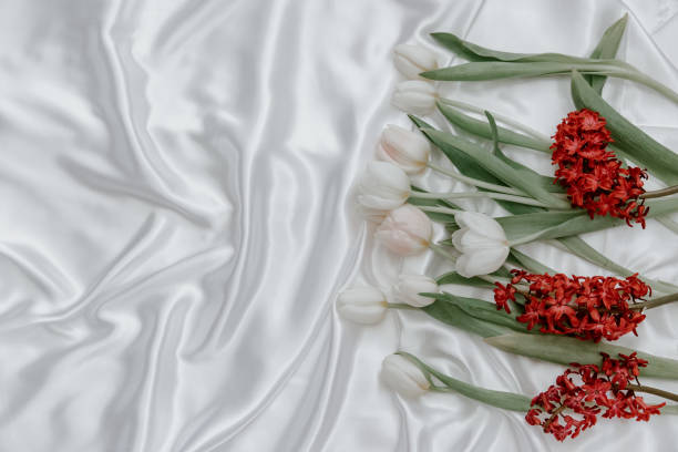 istock Flowers composition. Springtime  tulip flowers on white  silk background. Hello Spring. Flat lay, top view. Holiday Greeting Card for Womens Day and Mothers Day. 1308007199
