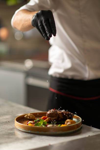 istock A male chef sprinkling salt on a dish in a commercial kitchen 1308007236