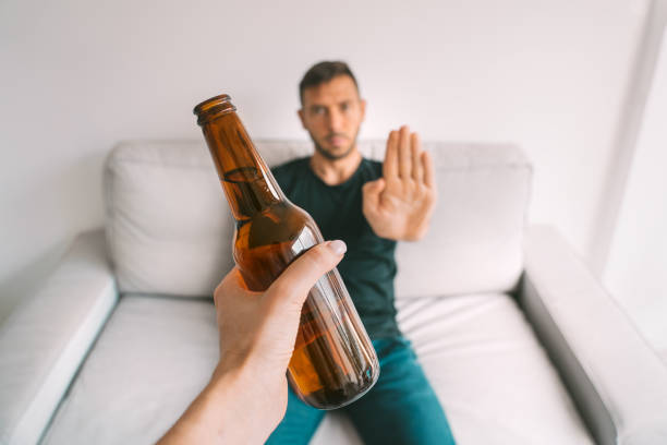 pas d’alcool. sain. le jeune homme refuse de boire la bière, faisant le geste d’arrêt à la bouteille de bière - non photos et images de collection