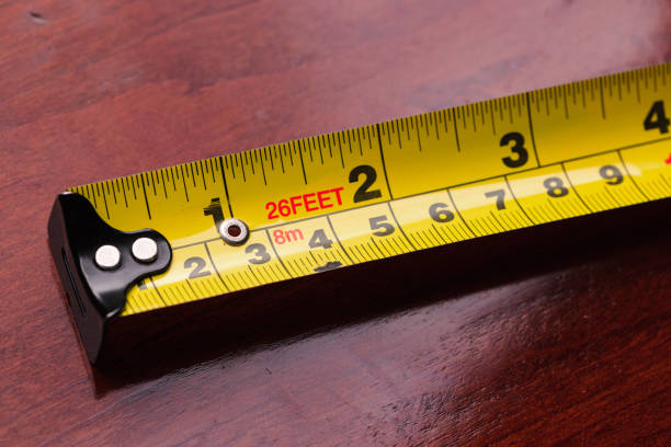 Part of a yellow tape measure Yellow tape measure on a dark wooden desk. measuring photos stock pictures, royalty-free photos & images