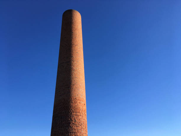 Detail of chimney on a brick factory under a clear blue sky