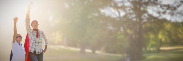 Composite image of mother and son pretending to be superhero Mother and son pretending to be superhero against park on sunny day superhero environment women green color stock pictures, royalty-free photos & images