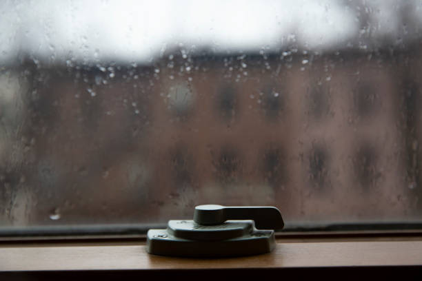 Close up of window latch. Window hasp. Rain drops on a glass.