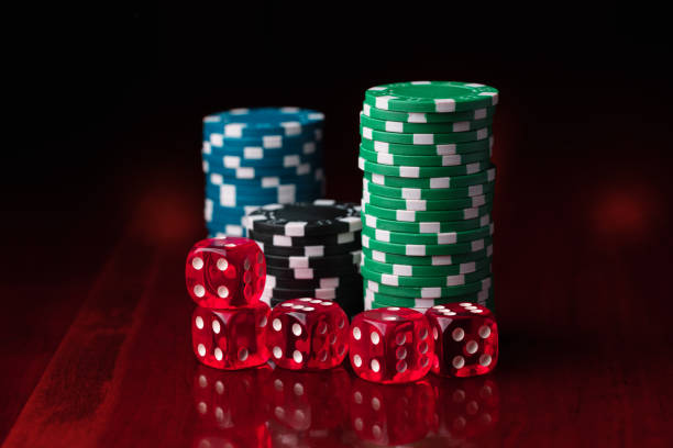 istock Group of gambling chips and red dice on a wooden surface 1308025083