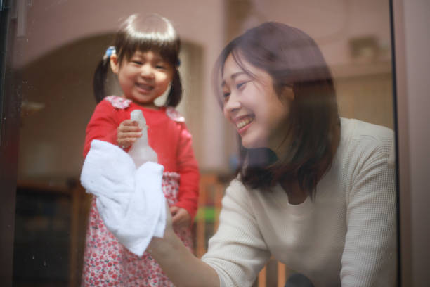 istock Parents and children cleaning windows 1308027661