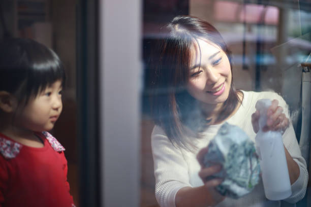 istock Parents and children cleaning windows 1308027668