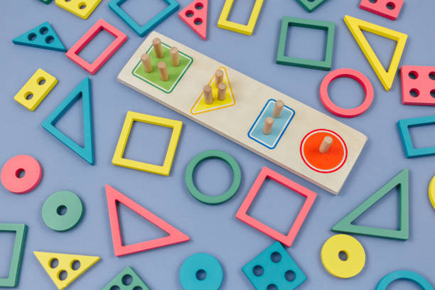 Multicolored wooden toys, blocks on violet background. Trendy puzzle toys. Geometric shapes: square, circle, triangle, rectangle. Educational toys for kindergarten, preschool or daycare. Close up juguetes multicolores de madera, bloques sobre fondo violeta. juguetes de rompecabezas de moda. formas geométricas: cuadrado, círculo, triángulo, rectángulo. juguetes educativos para jardín de infantes, preescolar o guardería. primer plano