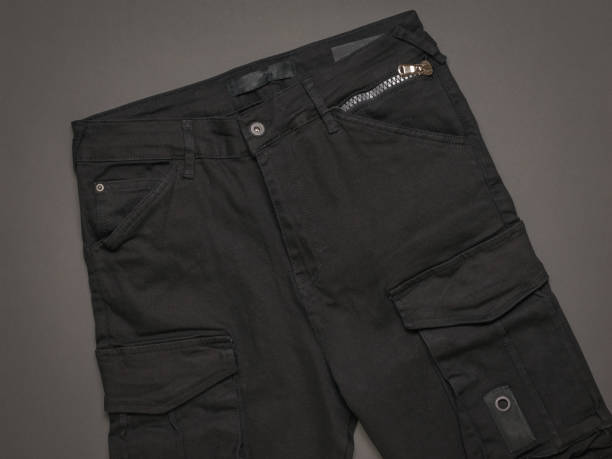 istock Black men's cargo jeans on a black background. 1308029258