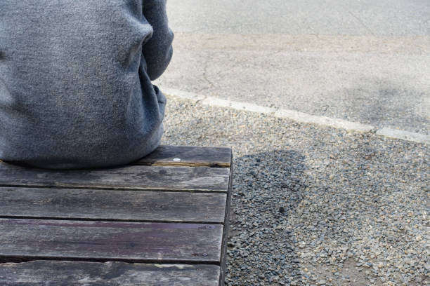 Image of a man restructuring and spending the day sitting on a park bench