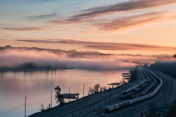 Sunrise at Fraser river, BC, Canada Fraser river and railway seen from Surrey in winter, long exposure. surrey british columbia stock pictures, royalty-free photos & images