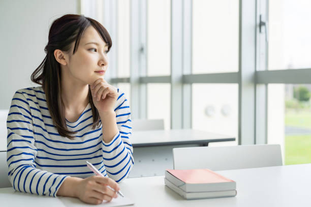 istock Asian female student studying in classroom. 1308043634