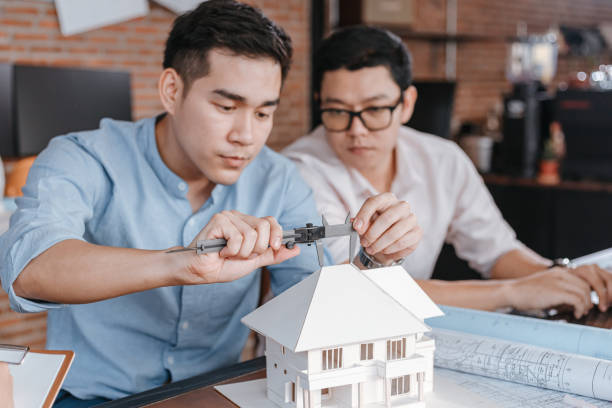 istock Engineering hands hold vernier caliper working and checking house model scale between meeting with businessman and businesswoman. Architecture, engineering, business and civil concept. 1308043665