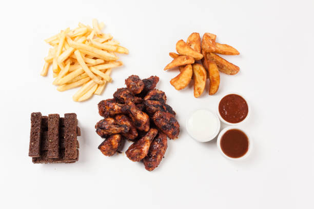Chicken wings with potatoes, Borodino bread and sauce on a white background. Top view