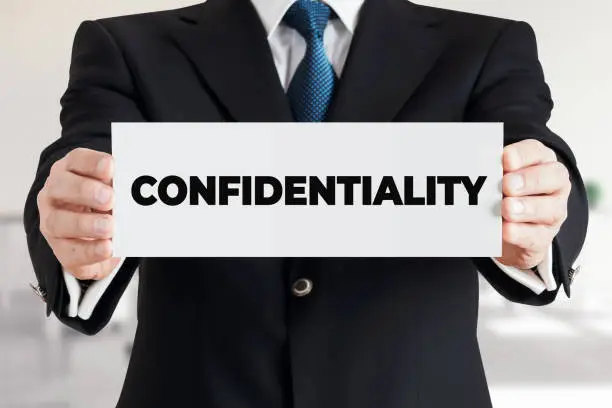 Photo of Businessman shows a banner with the word confidentiality. Business data or information secrecy protection