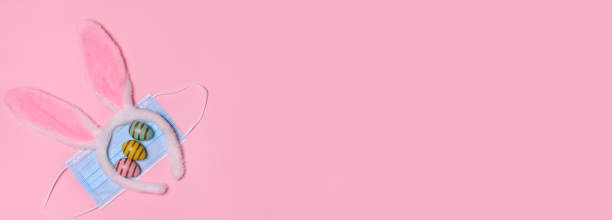 istock Easter pink ears rabbit , medical mask,easte eggs, on a pink background with copy space.Celebrating Easter during the coronavirus outbreak. Quarantine. Safe celebration concept. 1308047613