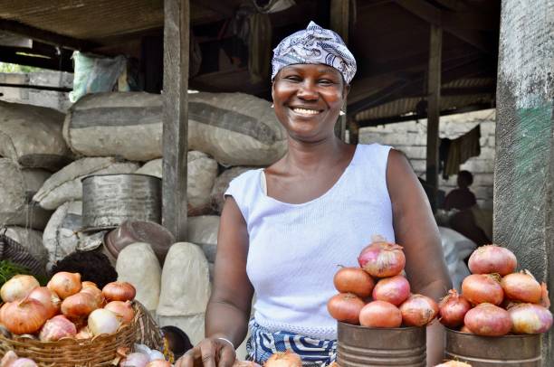 retrato de uma mulher sorridente vendendo cebolas no mercado - rural africa - fotografias e filmes do acervo