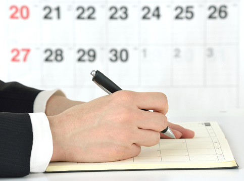 Business man checking schedule with notebook