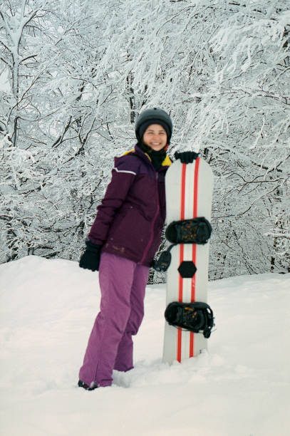 istock Woman snowboarding in mountains 1308060074