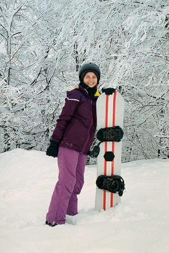Woman snowboarding in mountains. Camera film