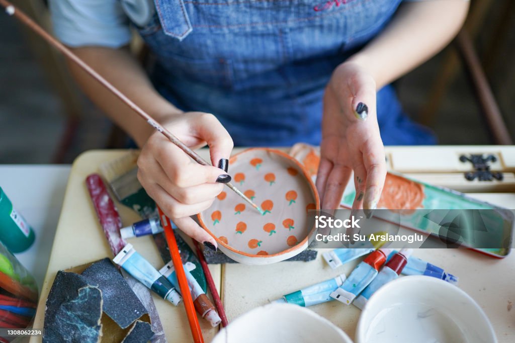 unrecognizable woman's hand paints ceramics Painting - Activity Stock Photo
