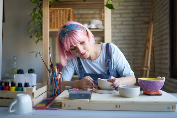 istock Pink haired young woman making ceramics at home 1308062282