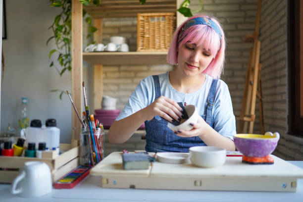 Pink Haired Young Woman Making Ceramics at Home Pink Haired Young Woman Making Ceramics at Home artist sculptor stock pictures, royalty-free photos & images