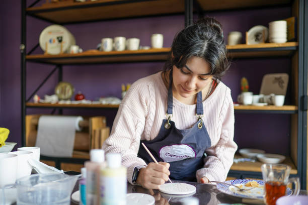 istock Adult woman paints ceramic in the ceramic workshop 1308063188