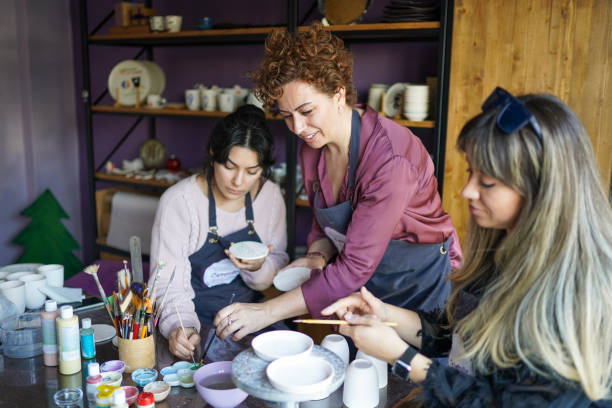 piccolo gruppo di donne che realizzano ceramiche presso un laboratorio di ceramica - potter small business pottery happiness foto e immagini stock
