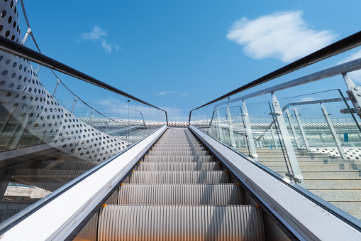 outdoor escalator against a blue sky