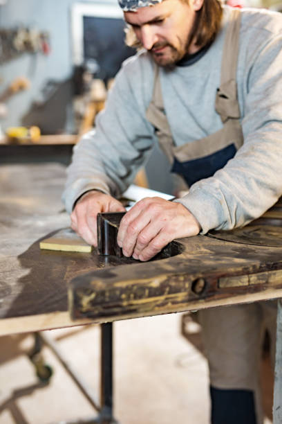 istock Male carpenter working on old wood in a retro vintage workshop. 1308065271