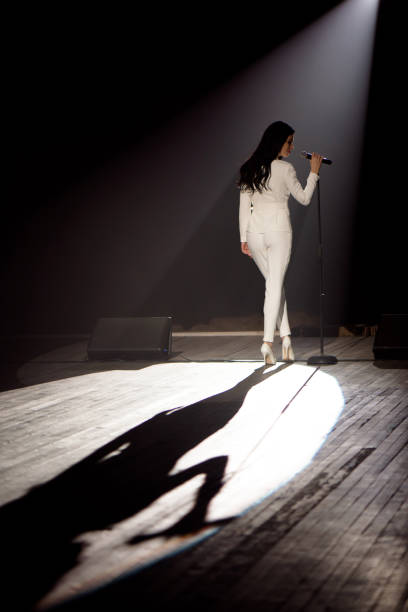 istock Singer on stage in a beam of white light. 1308066188