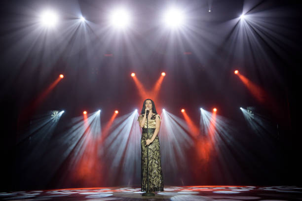 istock Young woman with microphone in hand on entertainment event. 1308066463