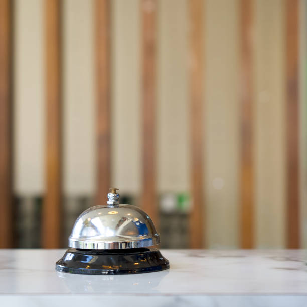 istock Closeup of a silver service bell on hotel reception desk. 1308067396