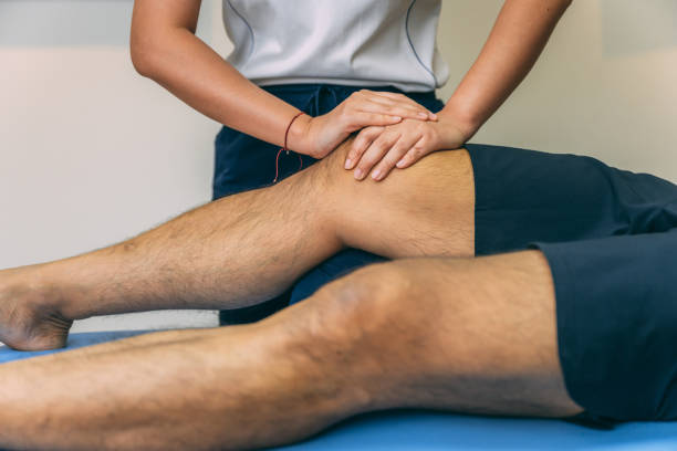 el paciente masculino está recibiendo fisioterapia, tratamiento o procedimiento está en su área de la rodilla. - cruciate ligament fotografías e imágenes de stock