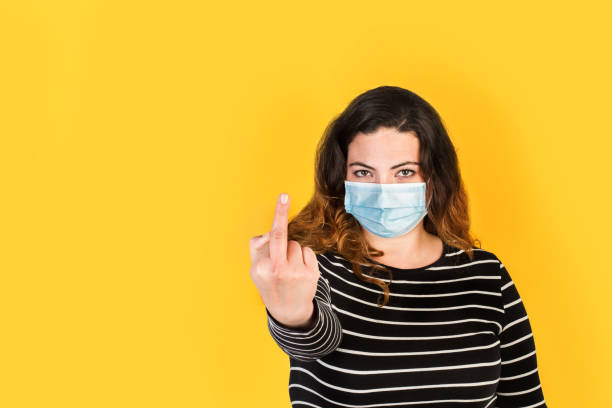 istock Curvy woman with surgical mask doing fuck gesture 1308070646