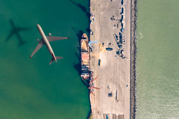 istock Airplane flying above the cargo ship. 1308076297