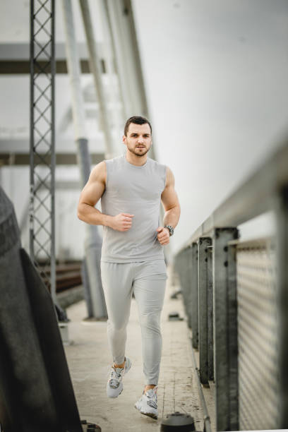istock Young man running outdoors in morning 1308078717