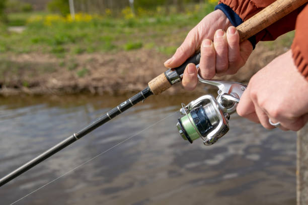 feche as mãos segurando vara de pesca e carretel de pesca - fishing rod fishing fishing reel casting - fotografias e filmes do acervo